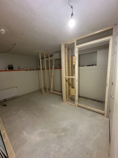 Lege ruimte met onvoltooid frame voor muren en een eenvoudige verlichting.